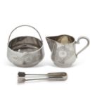 A cased Russian silver milk jug, sugar bowl and tongs, chased and engraved with floral scrolls,