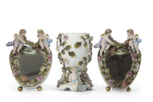 A Continental porcelain vase of oval shaped, supported by three cherubs, the base with Sitzendorf