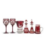 A group of Bohemian red flashed glass ware including a flared vase decorated with deer in a