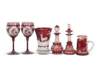 A group of Bohemian red flashed glass ware including a flared vase decorated with deer in a