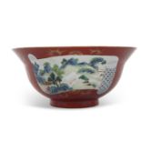 A coral ground Chinese porcelain flared bowl with reserves of polychrome landscapes, Chien Lung mark