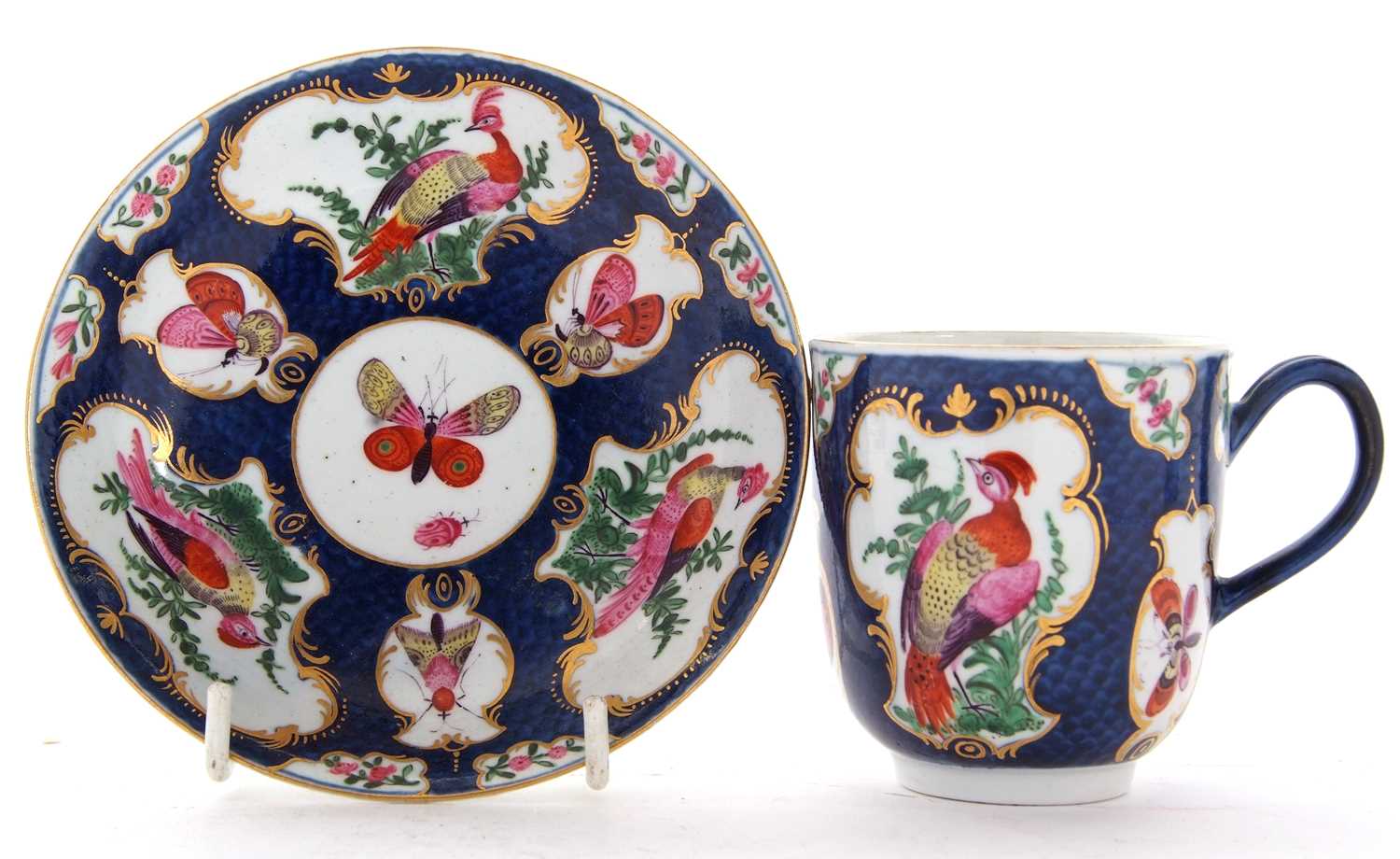 An 18th Century Worcester porcelain cup and saucer, the scale blue ground with reserves, painted - Image 2 of 3