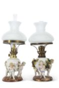 A pair of continental porcelain lamps with white frosted shades, the lamps decorated in the