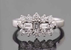 A diamond cluster ring, set with three baguette step cut diamonds to centre and surrounde by round