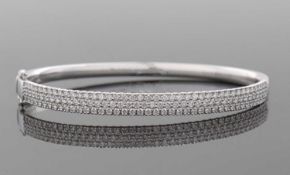 An 18ct diamond bangle, the white gold hinged bangle set to upper half with round brilliant cut