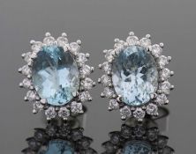 A pair of 18ct aquamarine and diamond earstuds, the oval aquamarines surrounded by small round