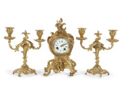 An early 20th Century French gilt brass clock garniture, the clock with white enamel dial with Roman