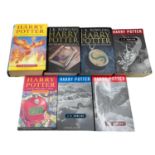 A collection of Harry Potter books, mixed editions and covers.