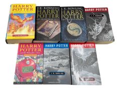 A collection of Harry Potter books, mixed editions and covers.