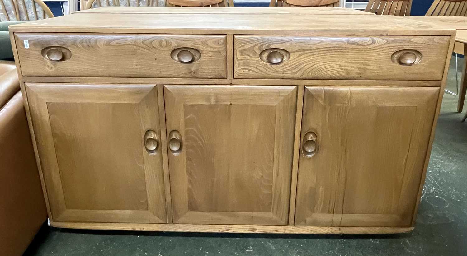 An Ercol light elm sideboard with two drawers over three panelled doors, 135cm wide