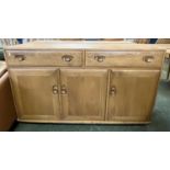 An Ercol light elm sideboard with two drawers over three panelled doors, 135cm wide