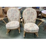A pair of Ercol light wood rocking chairs with stick backs and loose cushions