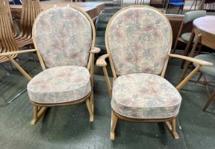 A pair of Ercol light wood rocking chairs with stick backs and loose cushions