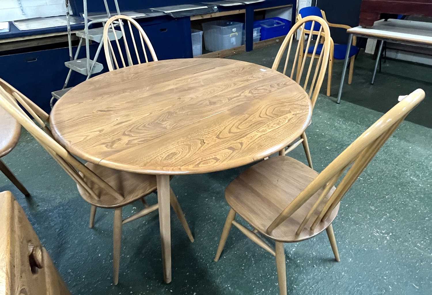 An Ercol drop leaf circular dining table with four accompanying hoop backed chairs, table 125cm