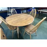 An Ercol drop leaf circular dining table with four accompanying hoop backed chairs, table 125cm