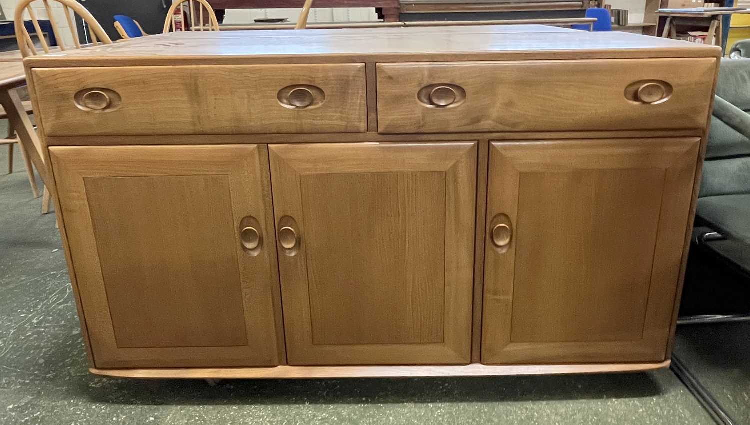 An Ercol light elm sideboard with two drawers over three panelled doors, 136 wide