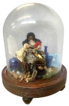 A glass dome on hardwood base, containing a diorama scene of a wooden peg doll in Victorian dress,