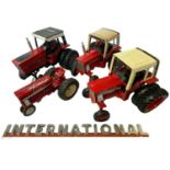 Four large scale die-cast model International tractors (2 repainted), together with an International