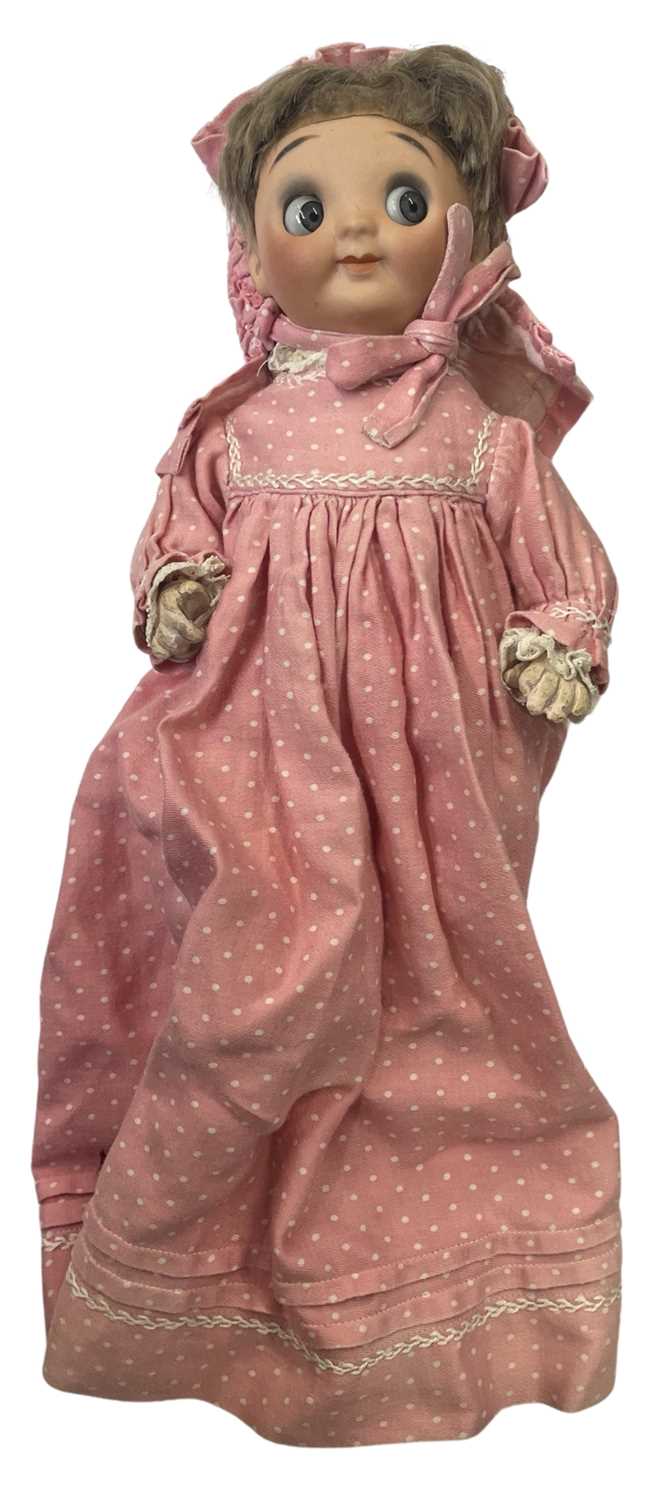 A bisque head Gebruder Heubach Einco 'Googly eye' doll, in pink spotted dress, woollen under-