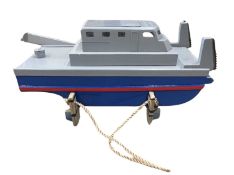 A wooden painted electric tug-boat on stand. Length approximately: 52cm