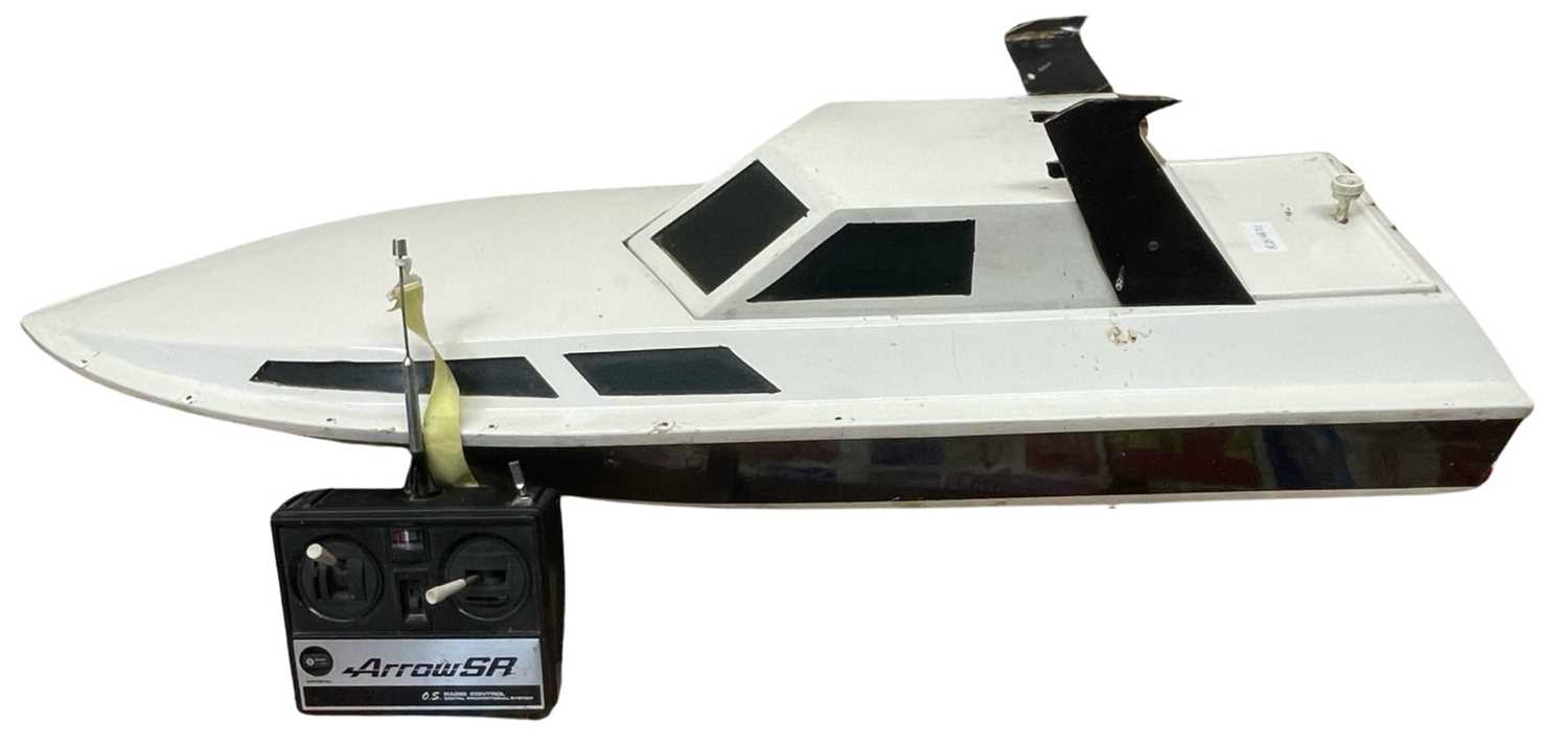 A large remote controlled speedboat with controller and on stand. Length approximately 96cm