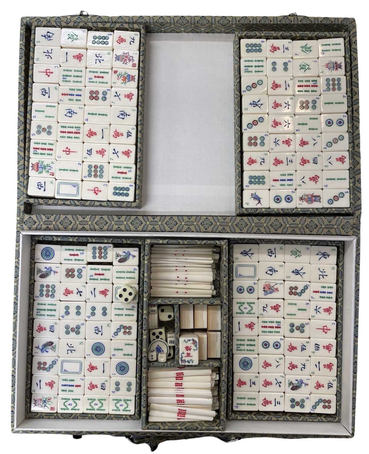 A vintage Mahjong set, within a silk-covered case