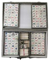 A vintage Mahjong set, within a silk-covered case