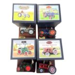 Four boxed Britains die-cast tractor models on wooden plinths, to include: - David Brown 900 -