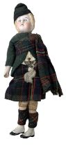 A small vintage bisque head doll, formed as a boy in Traditional Highland dress. With cloth body and