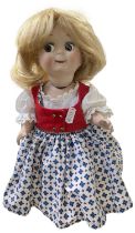 A reproduction German bisque head googly eye-eye doll, in patterned dress with blonde hair and