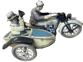 A vintage clockwork tinplate toy, modelled as a motorcyclist with passenger in side-car, possibly by