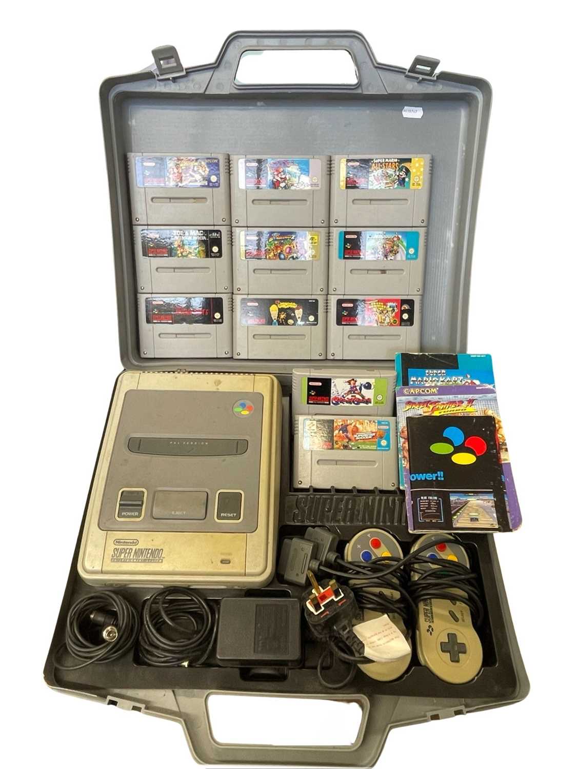 A retro Super Nintendo Entertainment System (SNES), in nintendo case with a quantity of game