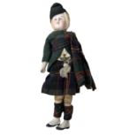 A small vintage bisque head doll, formed as a boy in Traditional Highland dress. With cloth body and