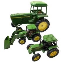 Two die-cast John Deere tractor models, plus one other.