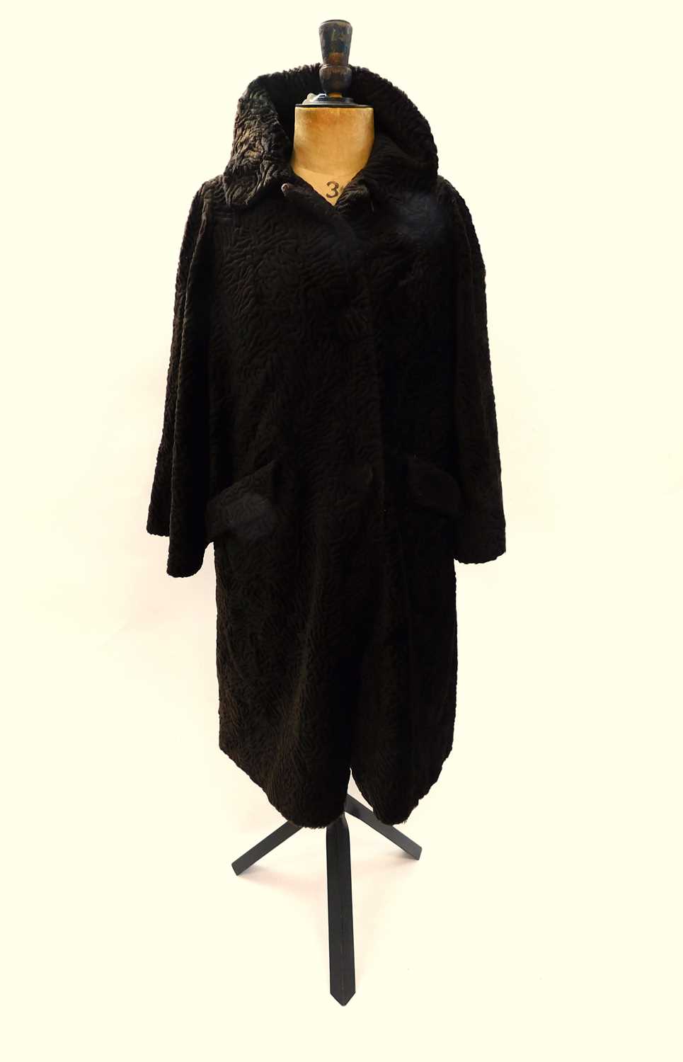 A mid 20th century brown astrakhan fur coat, single breasted with covered buttons, turn up collar