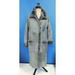 A lady's three quarter length sheepskin coat by Higgs, single breasted with three button front,