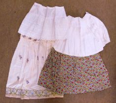 Four mid-20th century skirts, to include a floral patterned skirt, a cream cotton skirt with