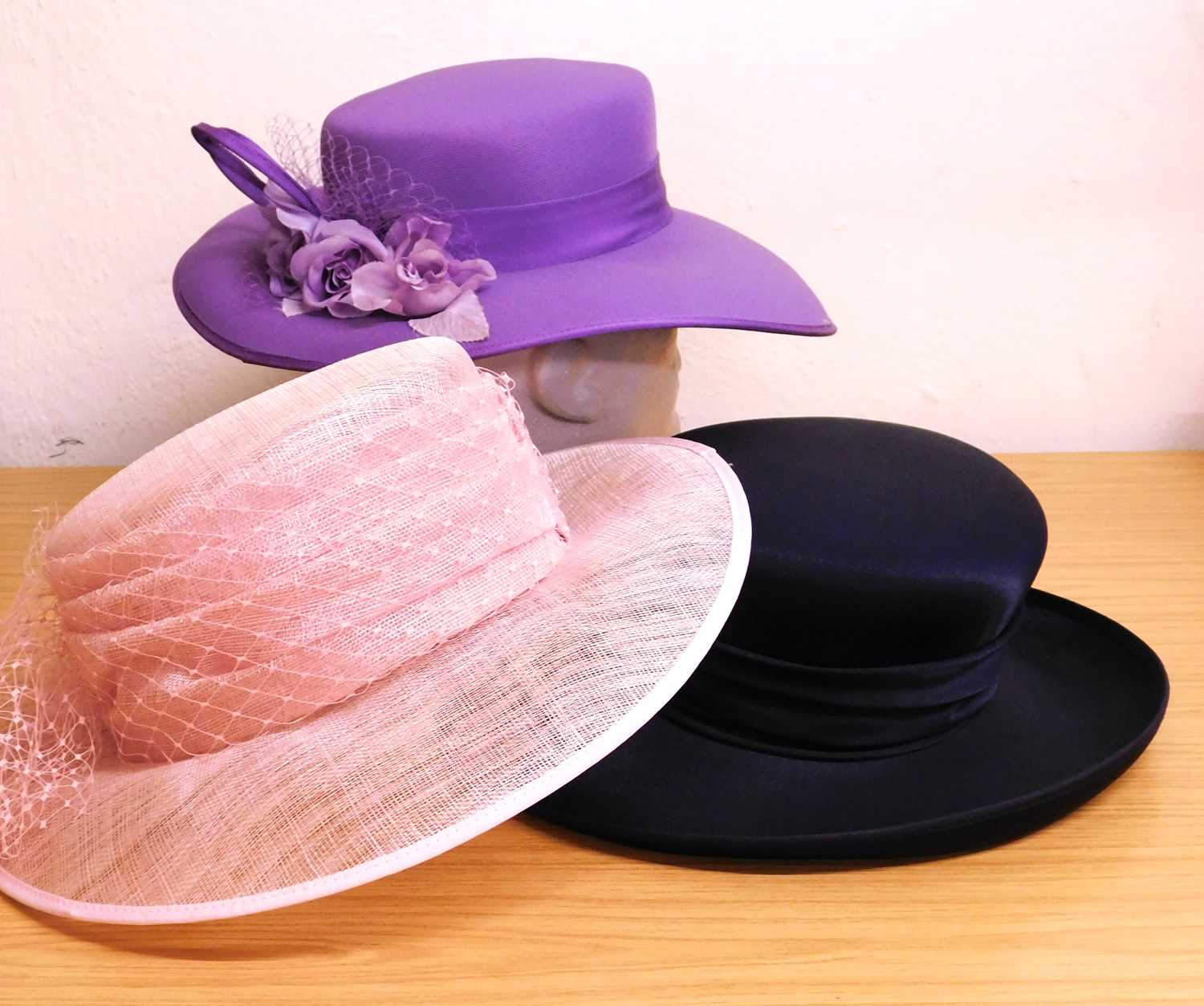Three occasion wear hats, to include a pink straw and net hat, a lavender and floral net decorated