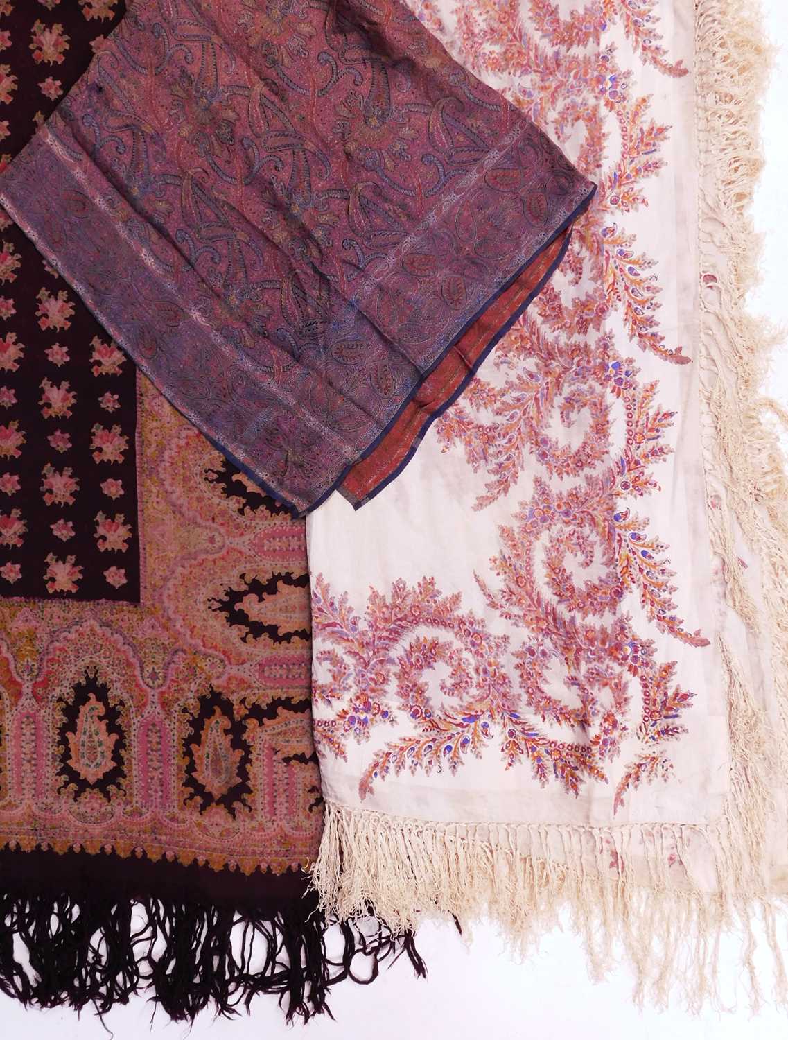 A cotton printed paisley shawl, a woven paisley silk scarf, a cream fringed printed paisley shawl (