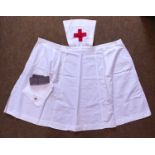 An early 20th century white cotton nurses apron, with grey grosgrain belt and white cotton square/