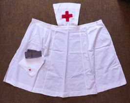 An early 20th century white cotton nurses apron, with grey grosgrain belt and white cotton square/