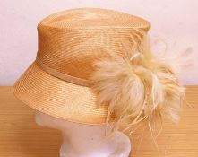 A straw hat by Failsworth Millinery, in biscuit colour with feather and bead detail