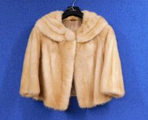A lady's blonde mink bolero with three quarter sleeves and deep round neck collar with fur covered