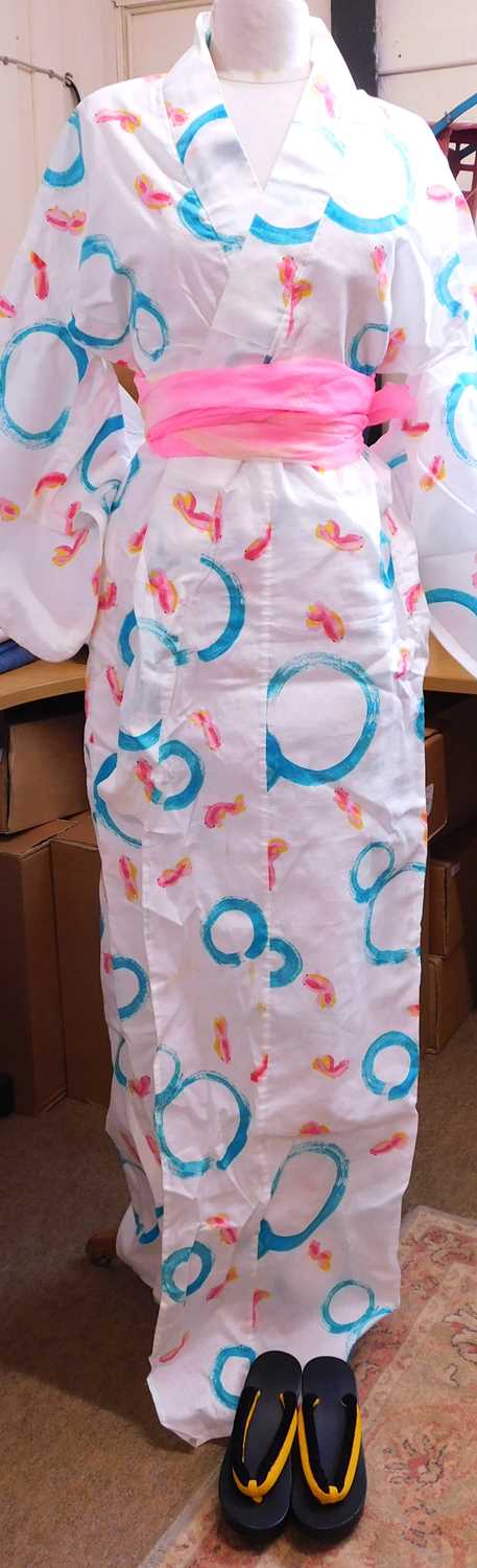 A modern cotton kimono, in white with printed pink fish and blue circles, with obi style sash and