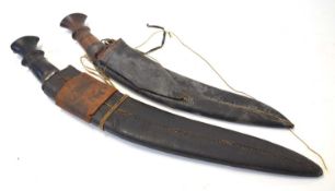Two 19th century Indian / Nepalese kukris in leather scabbards, lacking skinning tools. Largest with