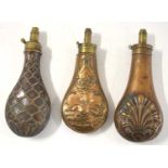 Three 19th century brass and copper powder flasks to include copper powder flask with dogs and a