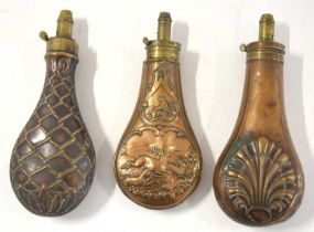 Three 19th century brass and copper powder flasks to include copper powder flask with dogs and a