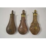 Three 19th century copper powder flasks to include: a copper bodied powder flask with star motif