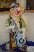 A large pottery model of a guitar playing clown