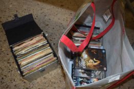 A small case of various assorted singles plus a further bag of assorted singles, DVD's etc